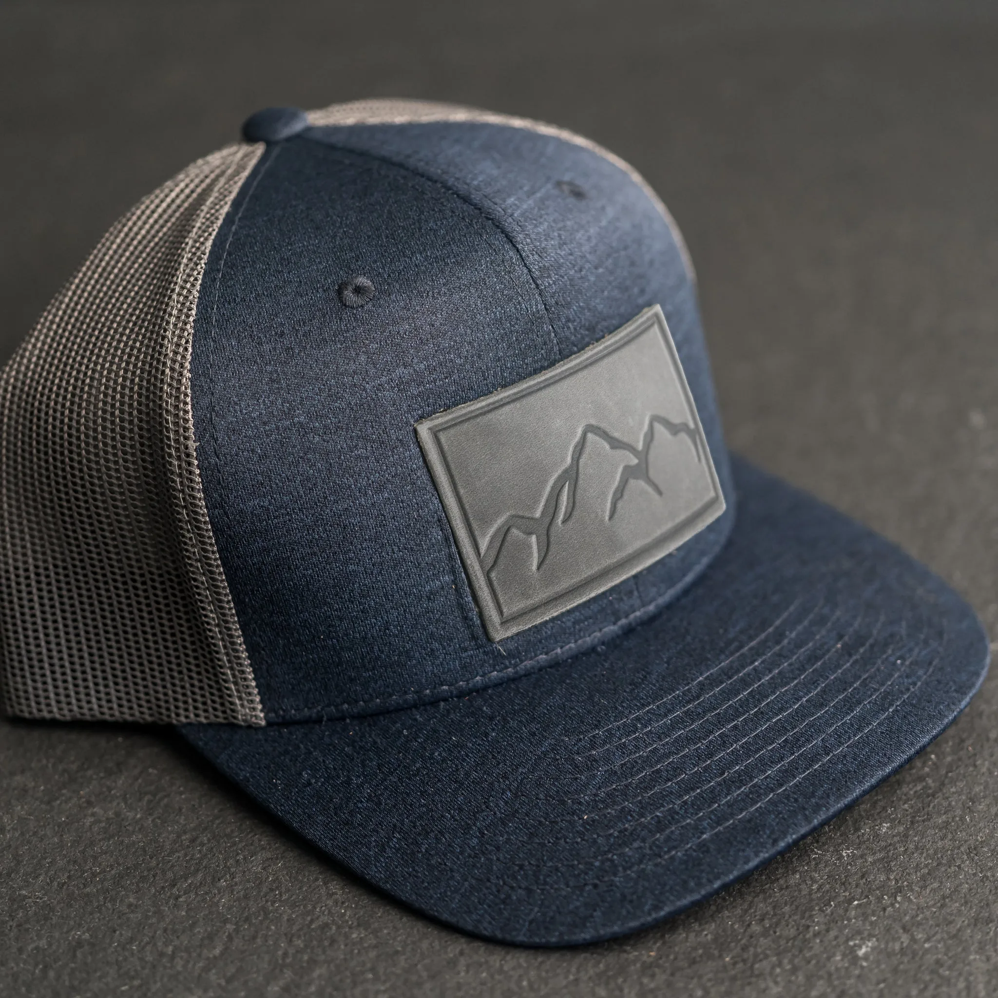 Leather Patch Performance Style Trucker Hat - Mountain Range Stamp